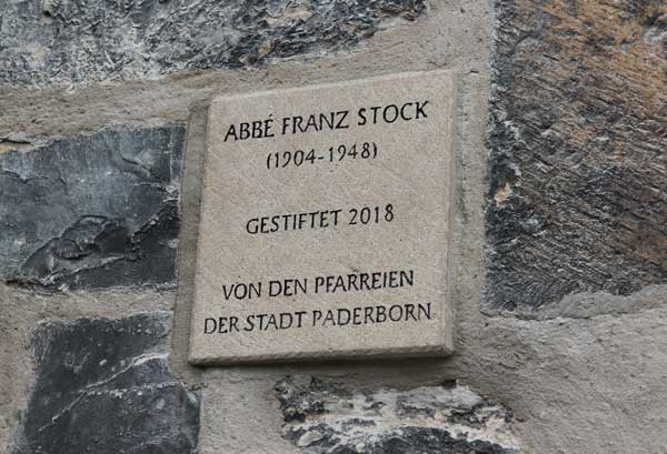 Eine Plakette neben der Skulptur dokumentiert, dass sie ein Geschenk der Paderborner Innenstadtgemeinden ist.